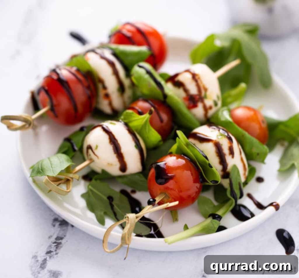 3 caprese skewers on white plate