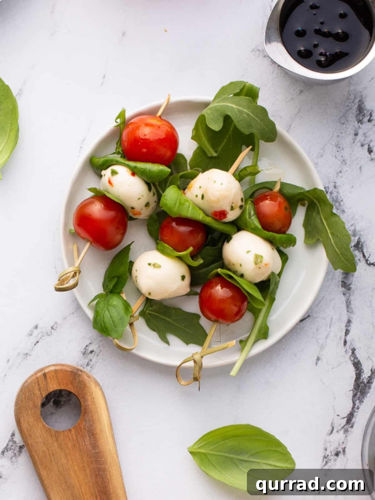 overhead picture of 3 Caprese skewers on white plate