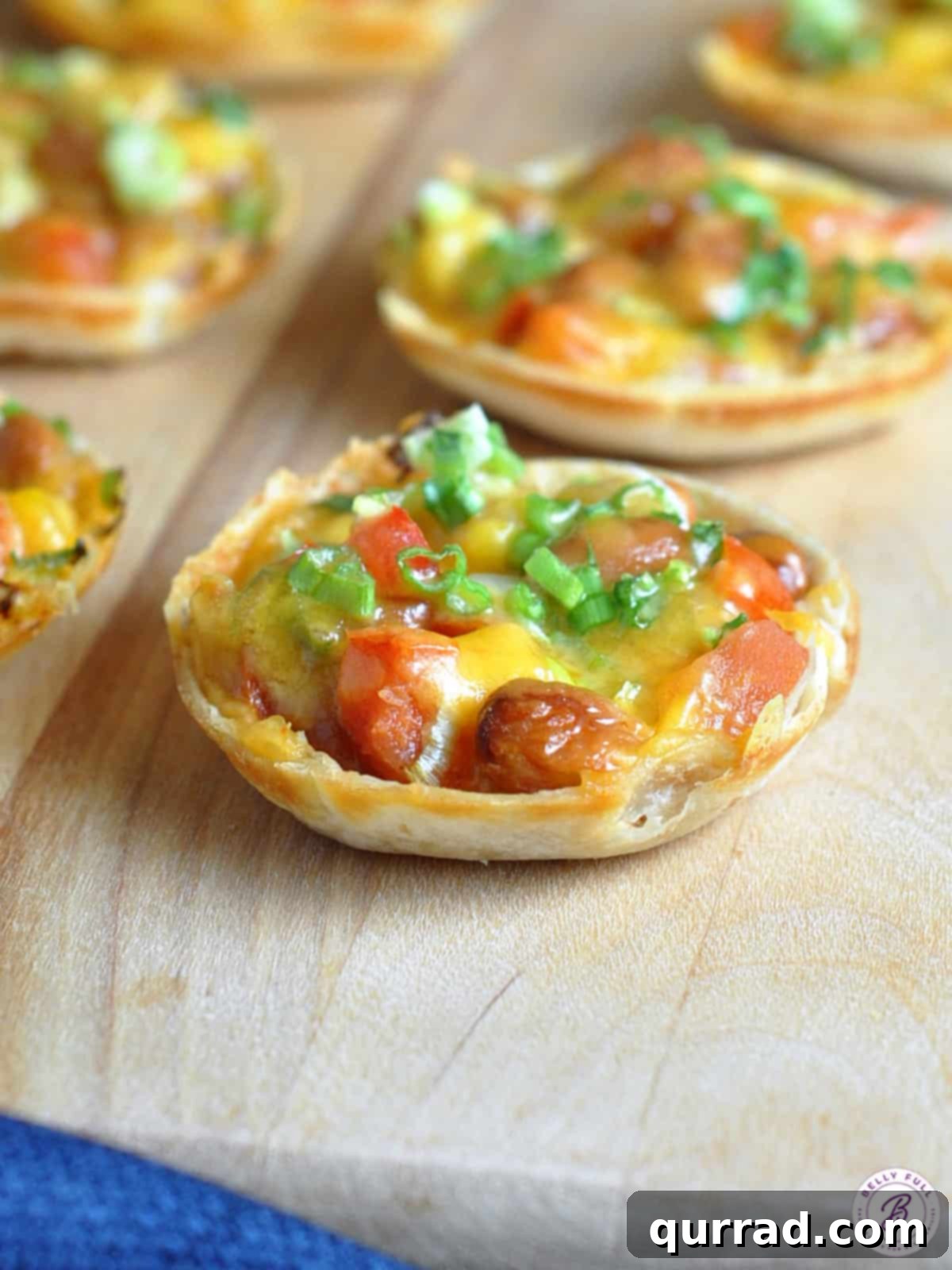 Baked mini tortilla rounds, generously filled with a hearty mixture of beans, corn, and melted cheese, fresh out of the oven
