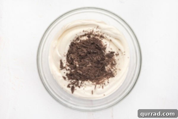 Decadent Tiramisu Dip 9 whipped mousse with grated chocolate on top in glass mixing bowl