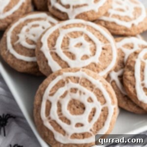 A white tray filled with chocolate sugar cookies with spiderweb icing, representing the final delicious product.