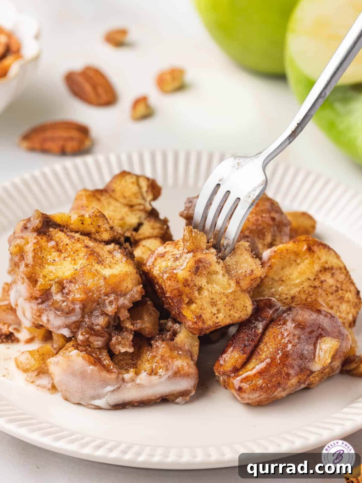 Gooey Caramel Apple Monkey Bread 5 cut up cinnamon rolls on plate with fork
