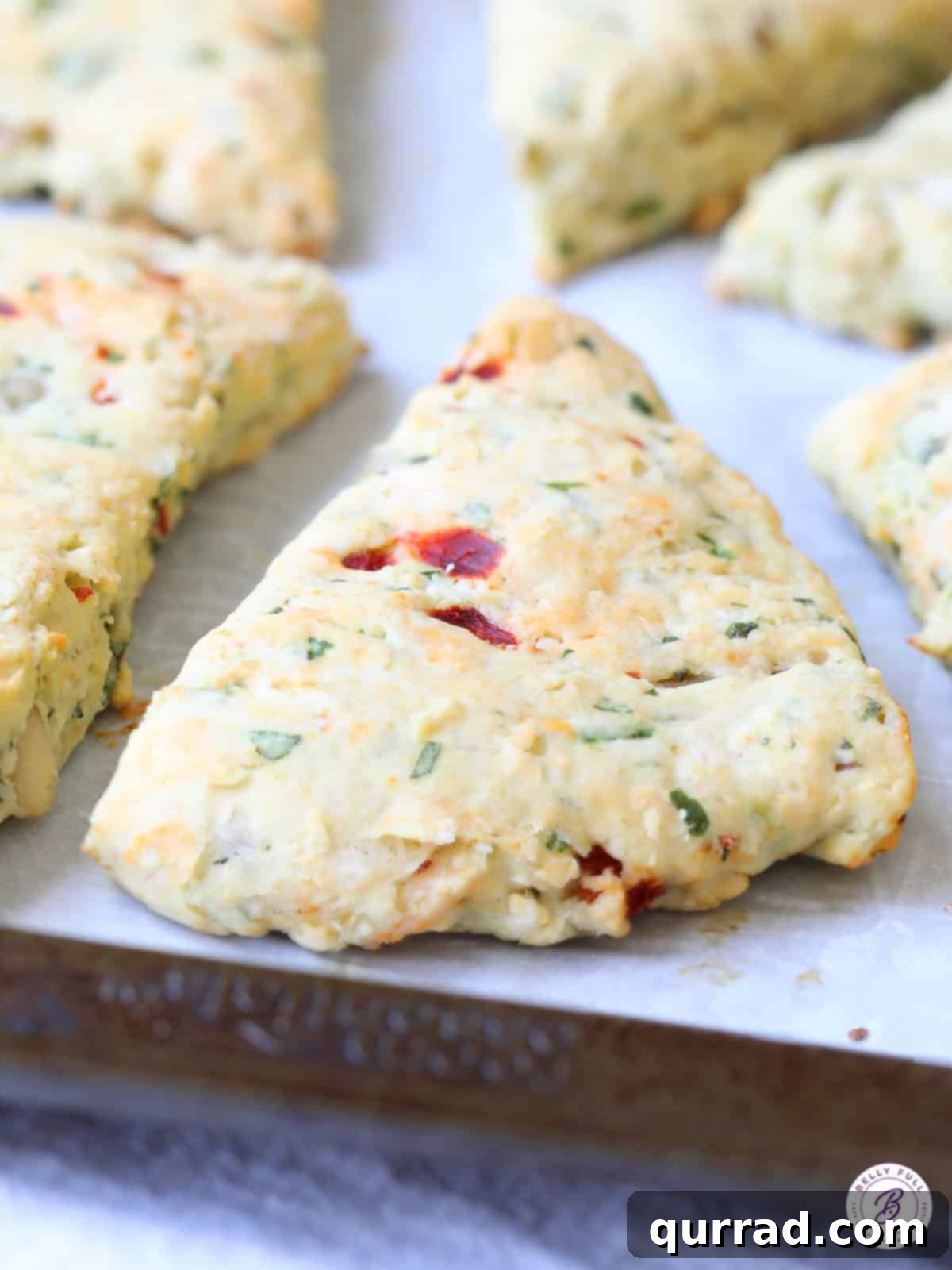 Freshly baked scones studded with sun-dried tomatoes and fresh basil leaves.