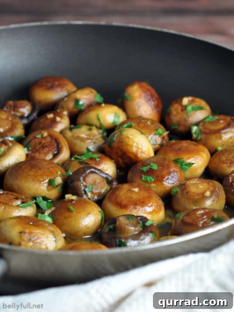 Sautéed Mushrooms with Garlic and Herbs 4 A vibrant close-up of golden-seared mushrooms sizzling in a hot skillet, surrounded by a rich butter and garlic sauce.