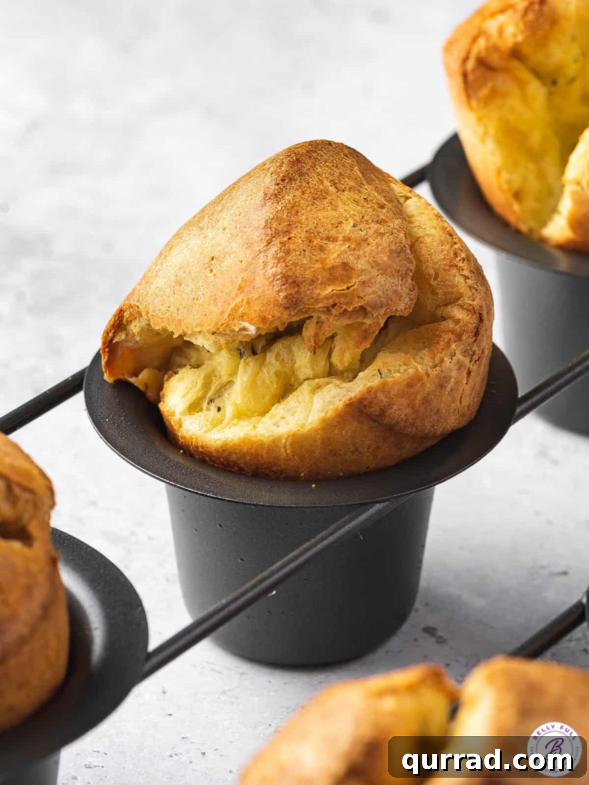 Fluffy Cheesy Popovers 4 close up popovers in pan with golden domed top
