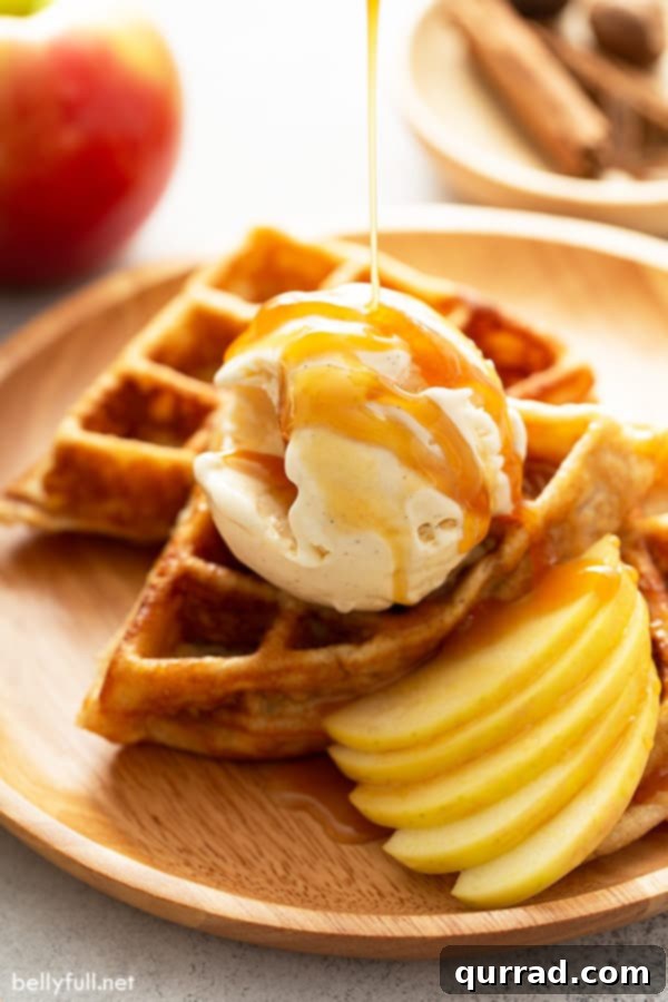 Apple Pie Waffles with Vanilla Ice Cream and Caramel Delicious apple pie waffles topped with vanilla ice cream and a generous caramel sauce drizzle, ready to be enjoyed.