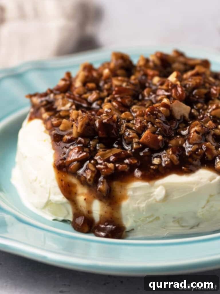 Close up French Quarter Cheese Spread with candied pecans, glistening with sweet syrup and nestled on a bed of creamy cheese.