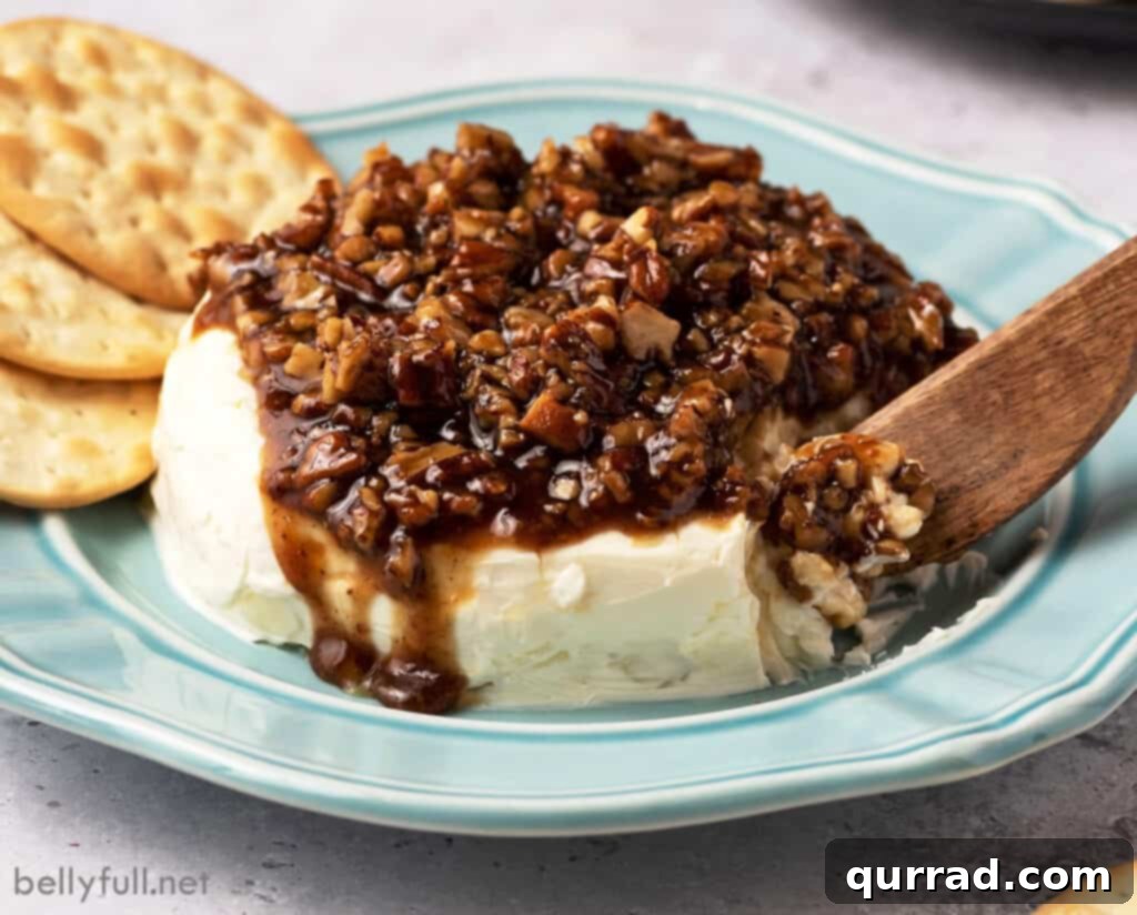 Cream cheese with sugared pecans flowing over the top, highlighting the rich texture and delicious appeal of the French Quarter Cheese Spread.