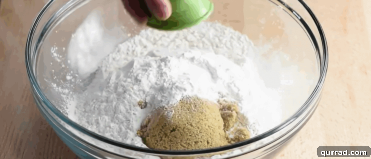 Preparing the batter for the beer bread in a glass bowl, showing dry ingredients being mixed.