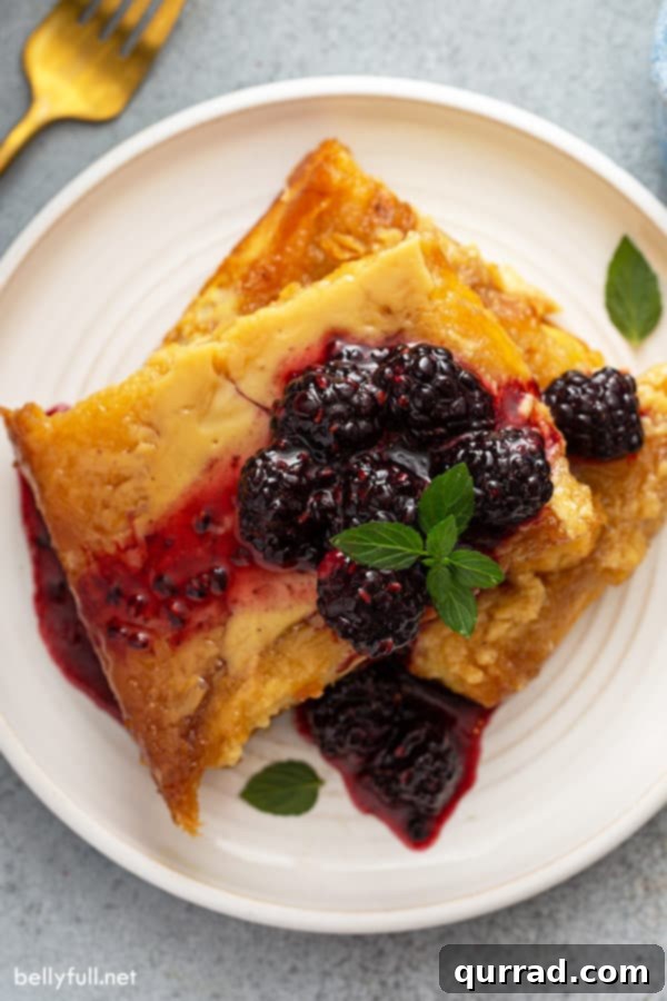 Wake Up To Brioche French Toast Casserole 5 overhead of french toast on white plate, topped with sugared blackberries