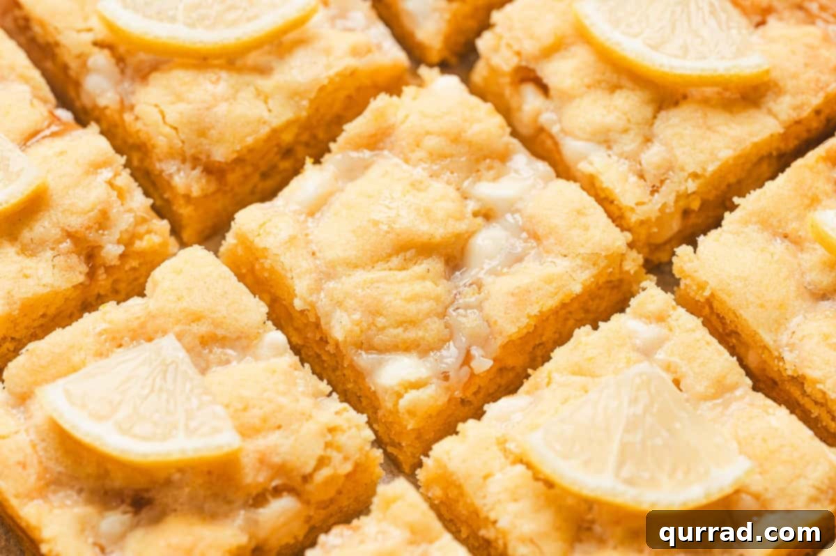 Zesty Lemon Bliss Bars 10 close up of a single lemon gooey bar with melted white chocolate and soft center