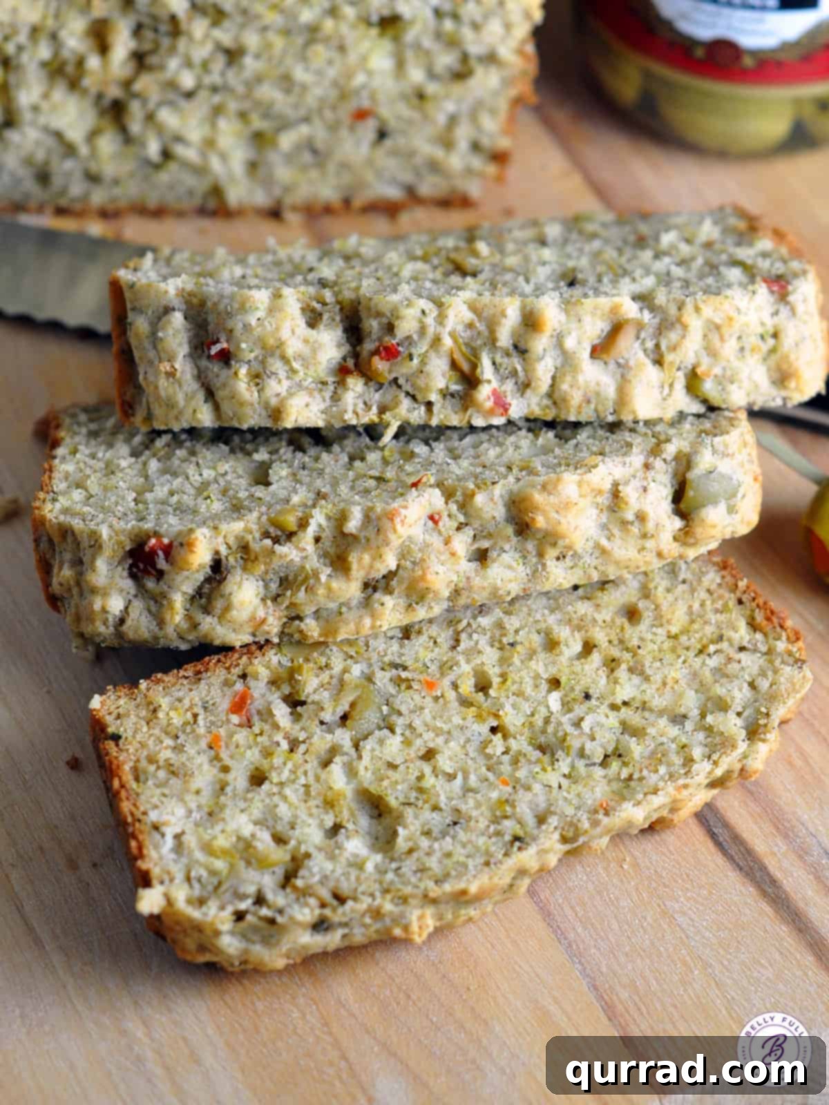 Mediterranean Olive Loaf 4 Three stacked slices of olive bread, showing the texture and visible olive pieces, ready to be enjoyed.