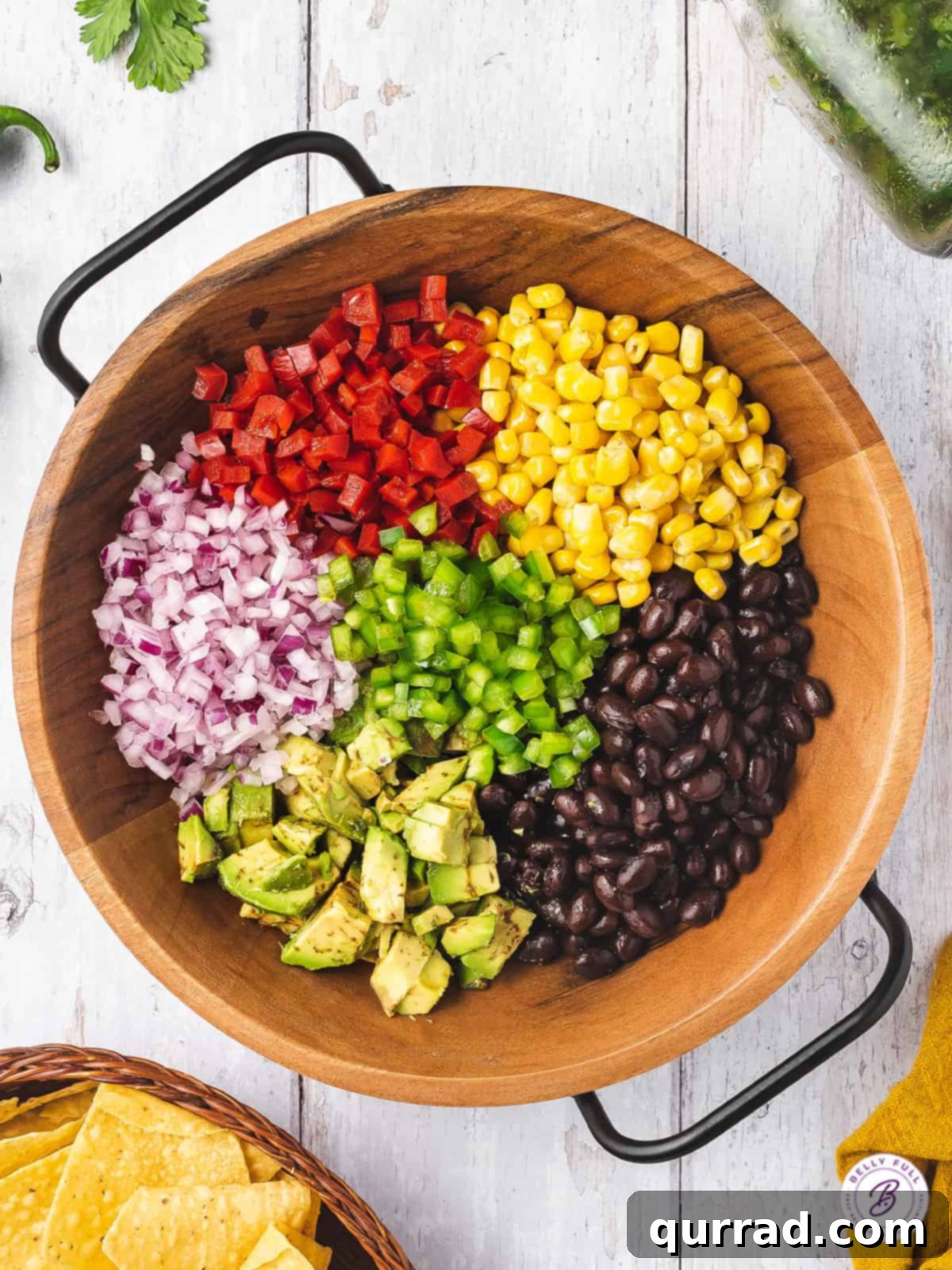 Fiesta Black Bean Corn Salsa 3 beans, corn, dived vegetables, and diced avocado in wooden bowl