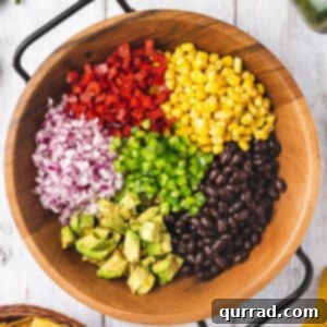 beans, corn, dived vegetables, and diced avocado in wooden bowl