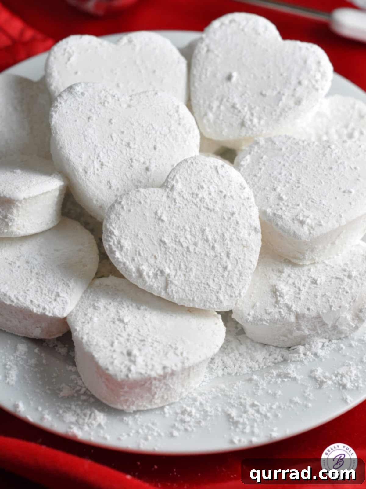 Plate full of heart shaped homemade marshmallows, showcasing their delicate texture and beautiful form.