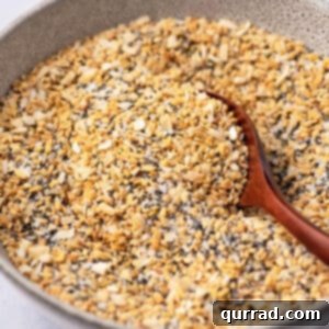 Everything Seasoning Blend 5 bowl of everything bagel seasoning with tiny wooden spoon