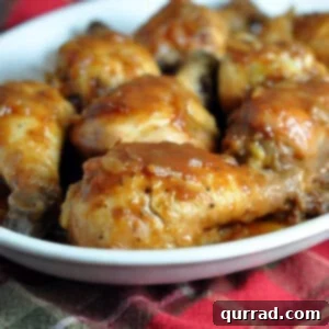 Slow cooked chicken coated in a rich, glossy sauce, ready to be served over a bed of fluffy white rice or mashed potatoes.