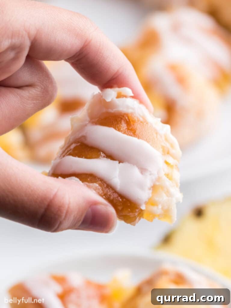 Island Escape Monkey Bread 5 hand holding a chunk of glazed biscuit
