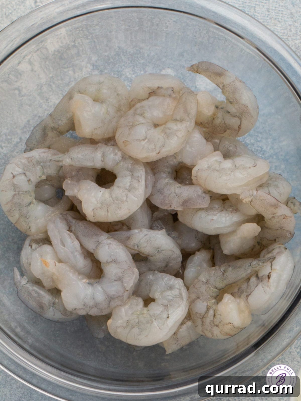 Sun-Kissed Shrimp with Feta and Tomatoes 3 A bowl of fresh, raw large shrimp, peeled and deveined, ready for cooking, illustrating preparation steps for the recipe.