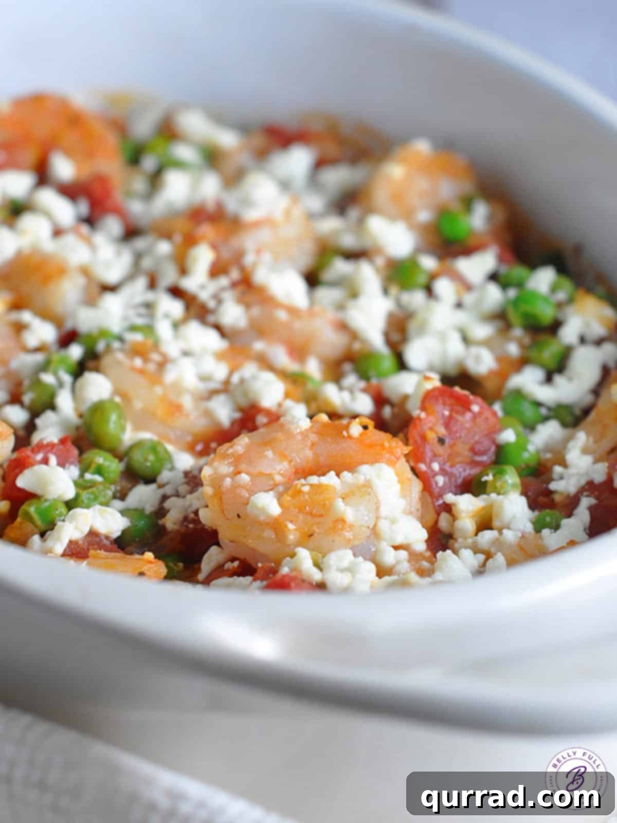 Sun-Kissed Shrimp with Feta and Tomatoes 4 A bubbling casserole dish of baked shrimp with tomatoes, peas, and melted feta cheese, garnished with fresh parsley, just out of the oven.