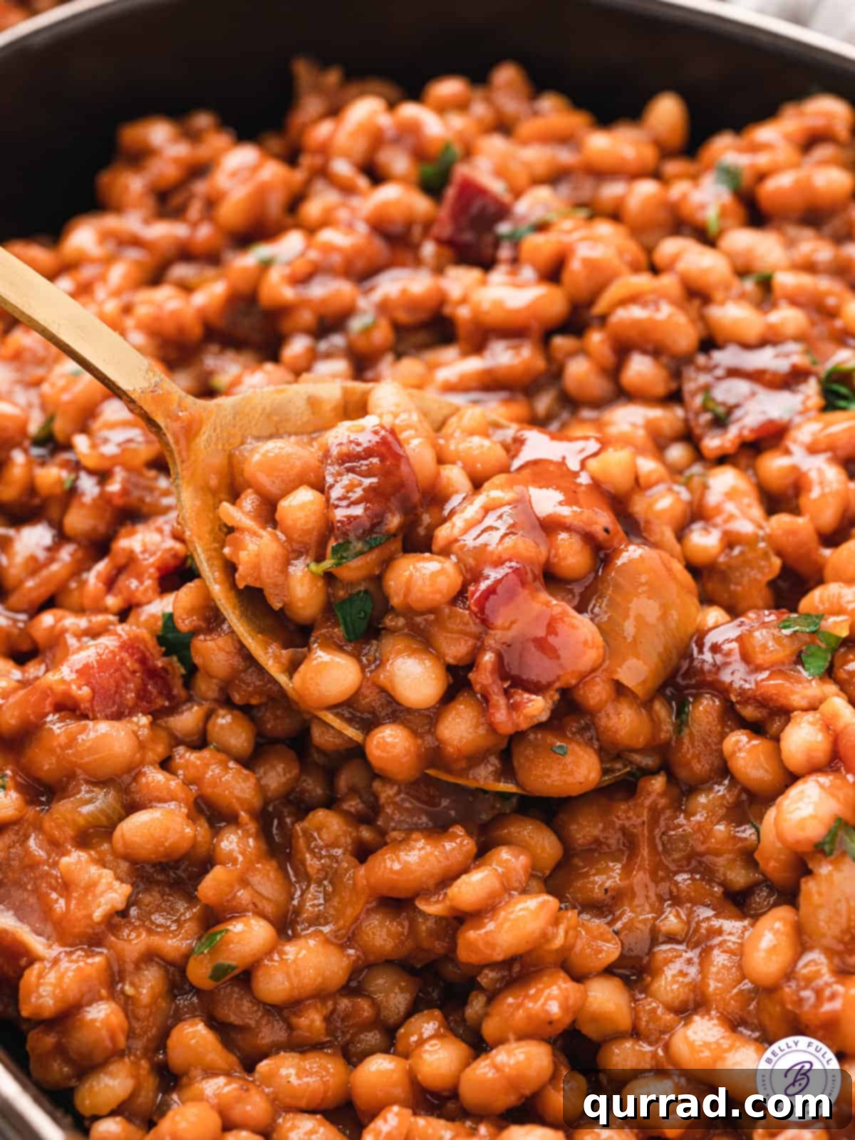 Grandma's Secret Baked Beans 2 close up spoonful of saucy molasses beans with bacon