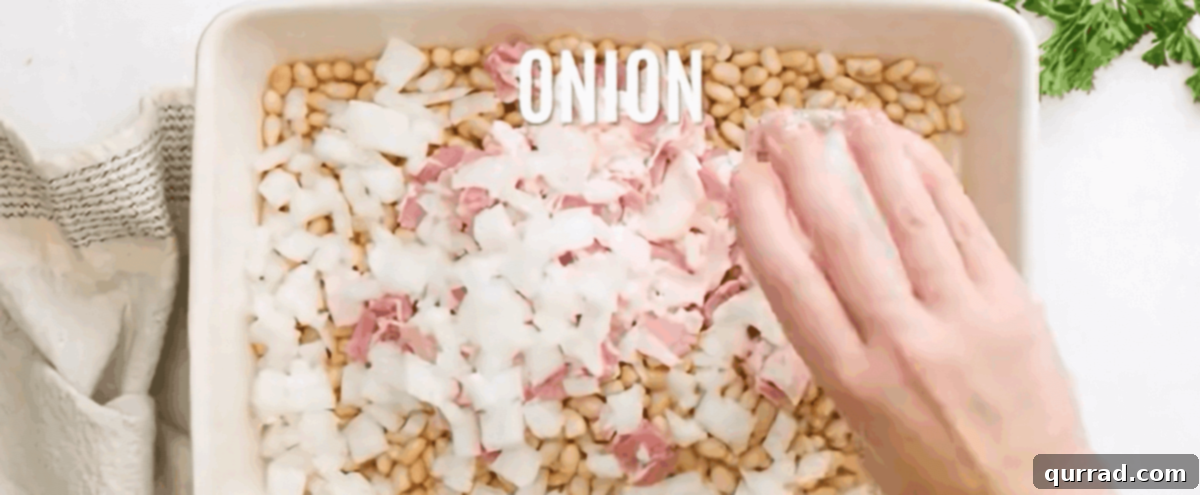 Grandma's Secret Baked Beans 4 Adding beans, bacon and onion to a casserole dish.
