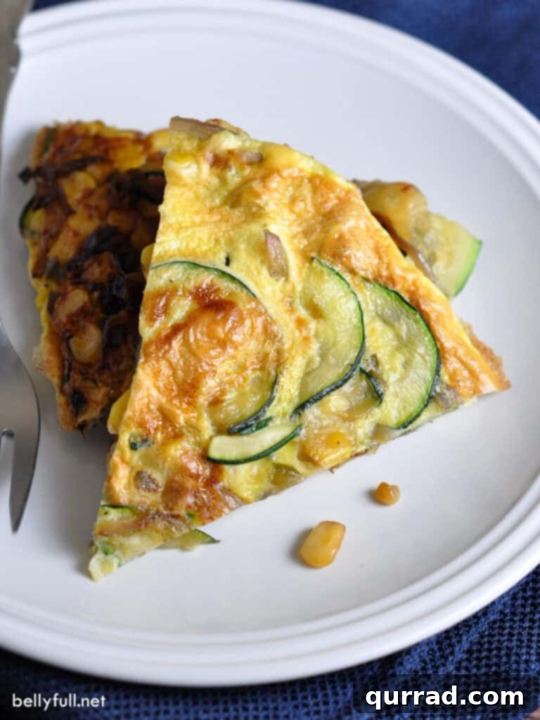 Desert Sunrise Frittata 2 A beautifully presented overhead slice of egg frittata, showcasing vibrant zucchini and corn, ready to be enjoyed.