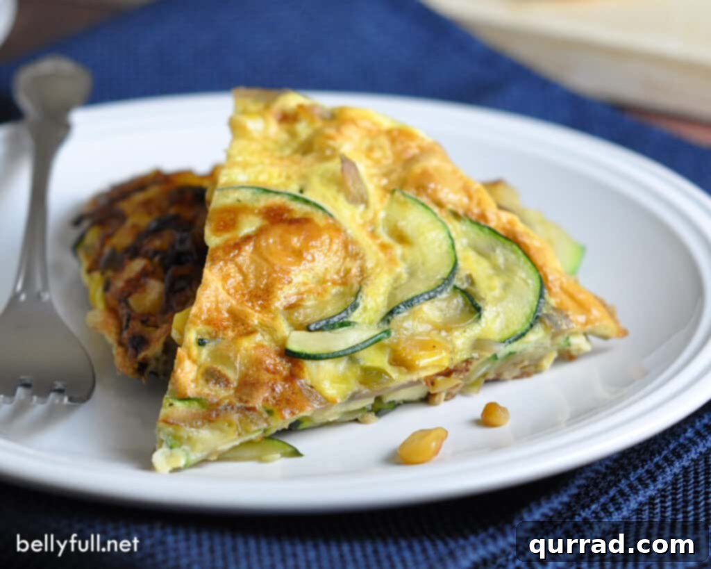 Desert Sunrise Frittata 4 A vibrant, round egg frittata slice, rich with zucchini and corn, presented on a white plate ready for serving.