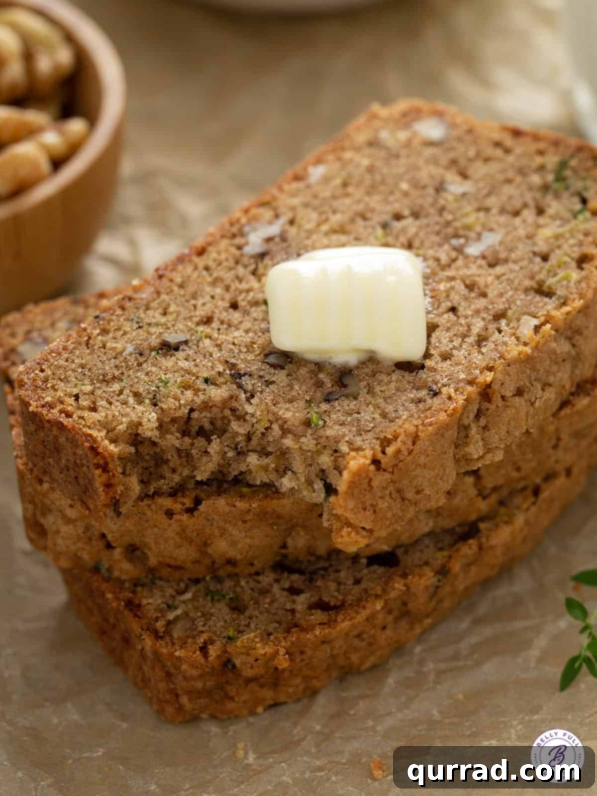 Quick bread with zucchini and a pat of butter, showcasing its moist texture and golden-brown crust.