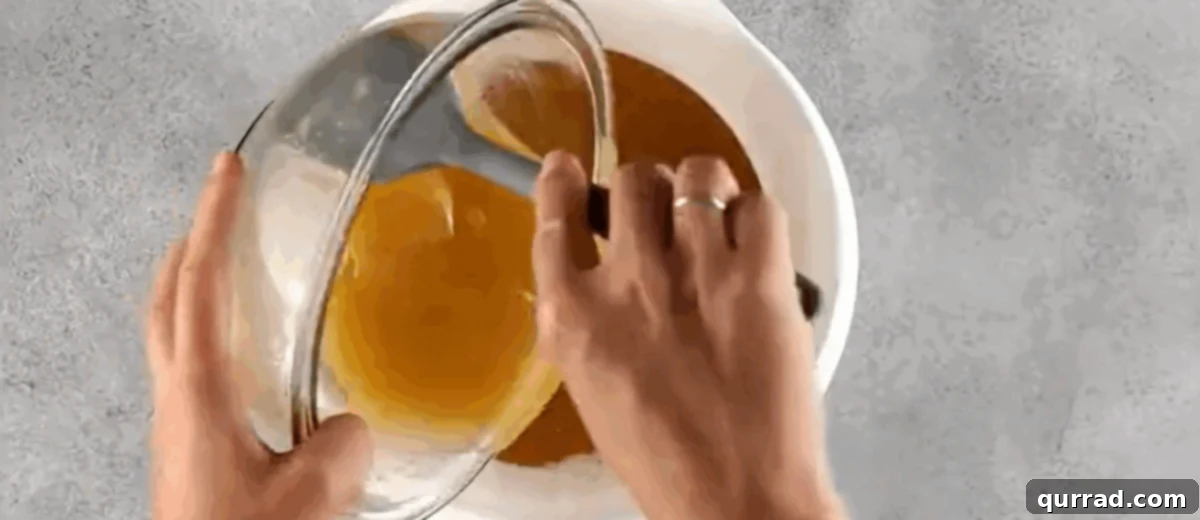 The moment wet ingredients are added to dry ingredients in a bowl, ready to be gently mixed.