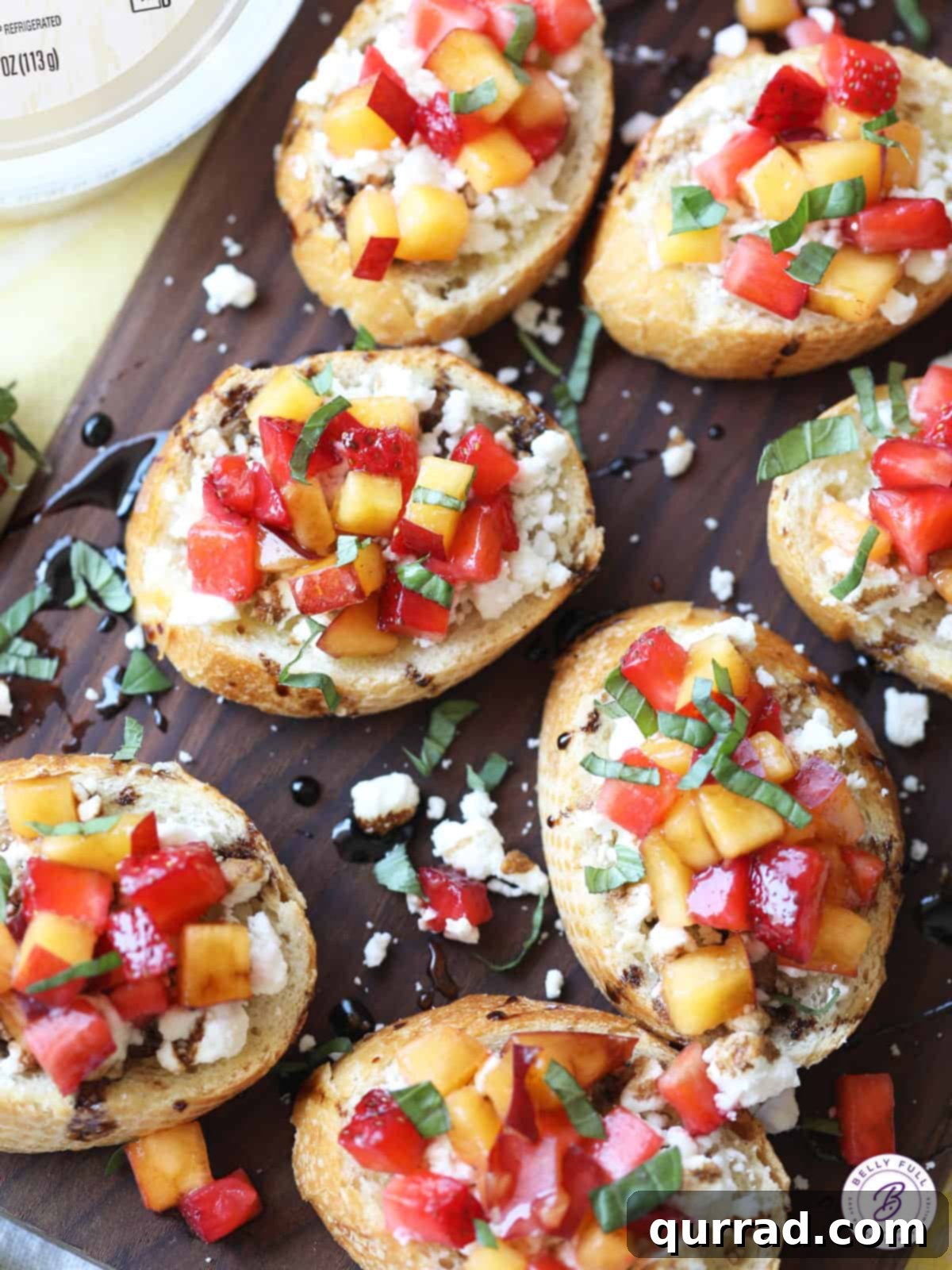 Sweet Summer Toasts 4 Beautifully assembled bruschetta, featuring diced fruit over creamy goat cheese on golden toasted bread, drizzled with balsamic glaze and honey.