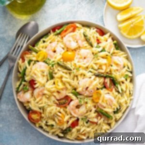 Bright Lemon Orzo Pasta Salad 5 overhead of Orzo Salad with shrimp, asparagus, and tomatoes in serving bowl