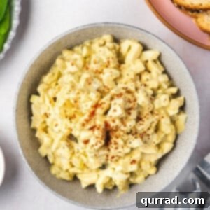 Overhead shot of a bowl of creamy egg salad garnished with paprika, ready to be served.
