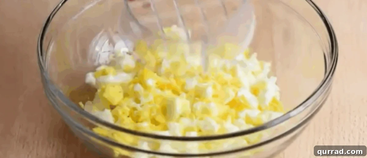 Creamy Egg Salad 5 Finely chopped hard-boiled eggs in a clear glass bowl, showcasing their creamy texture, ready to be mixed into the dressing.