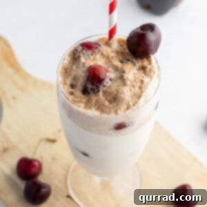 Cherry Cloud Float 6 Cherry ice cream float in tall glass with frozen cherries on top, a perfect summer drink.