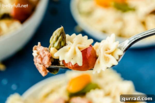 Effortless Italian Pasta Salad 3 A single portion of Italian Pasta Salad elegantly presented on a fork, ready to be enjoyed.