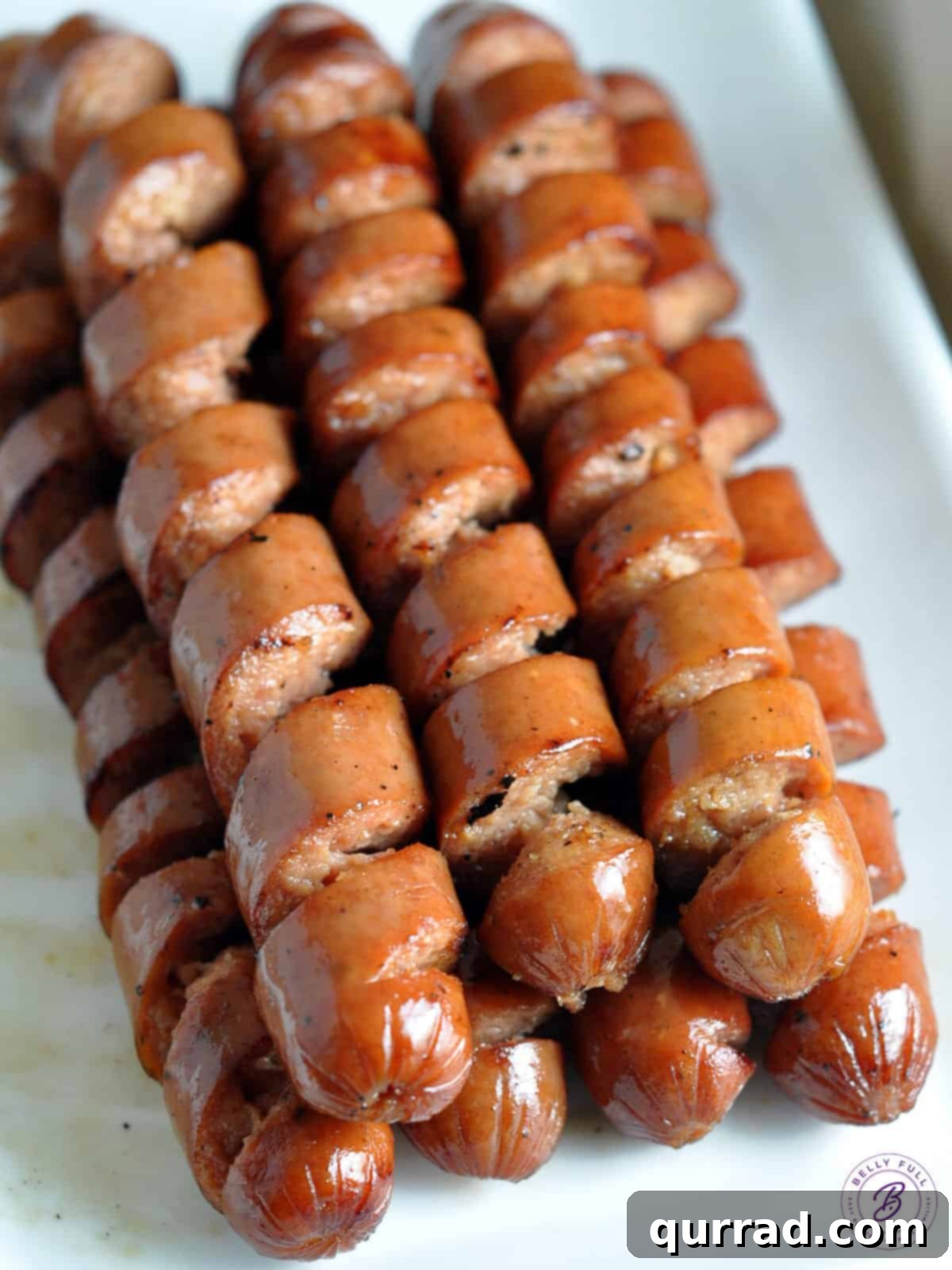 Frank & Fixings 5 A stack of beautifully spiral cooked hot dogs, ready to be served at a party, showcasing an innovative grilling technique.