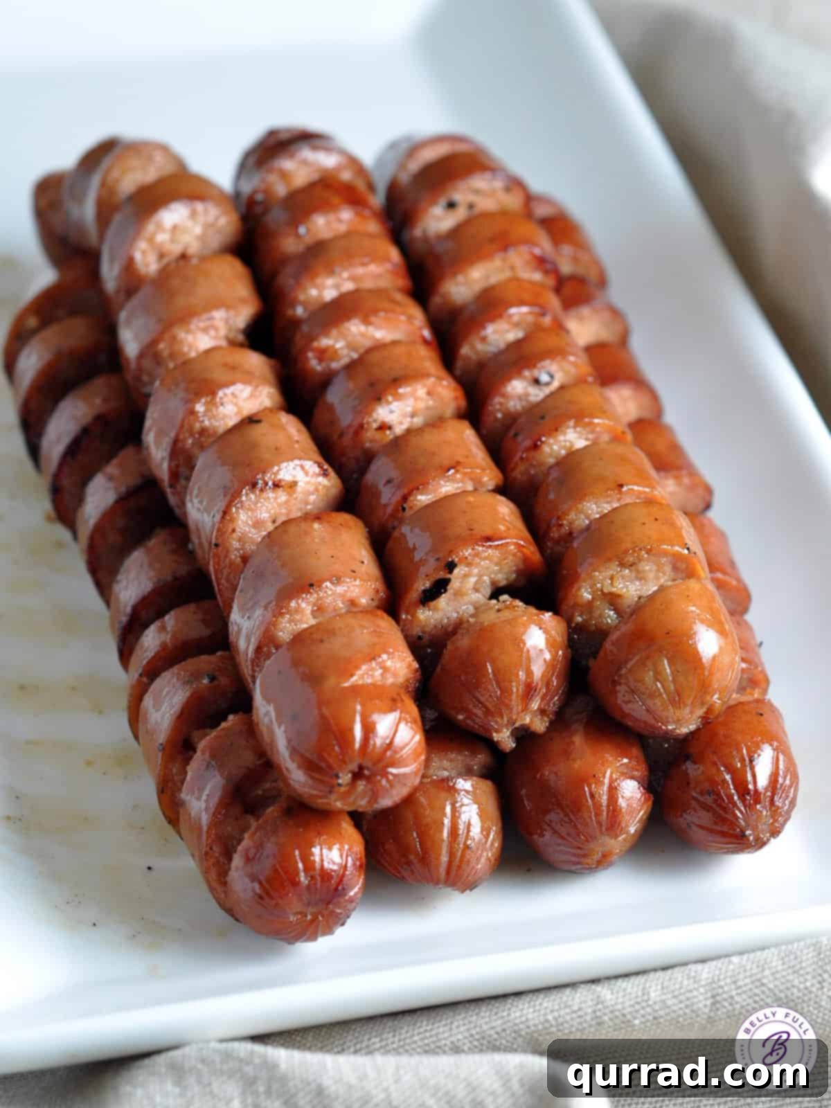 Sizzling Spiral Hot Dogs 2 Stack of perfectly spiral grilled hot dogs on a serving platter, showcasing their unique texture.