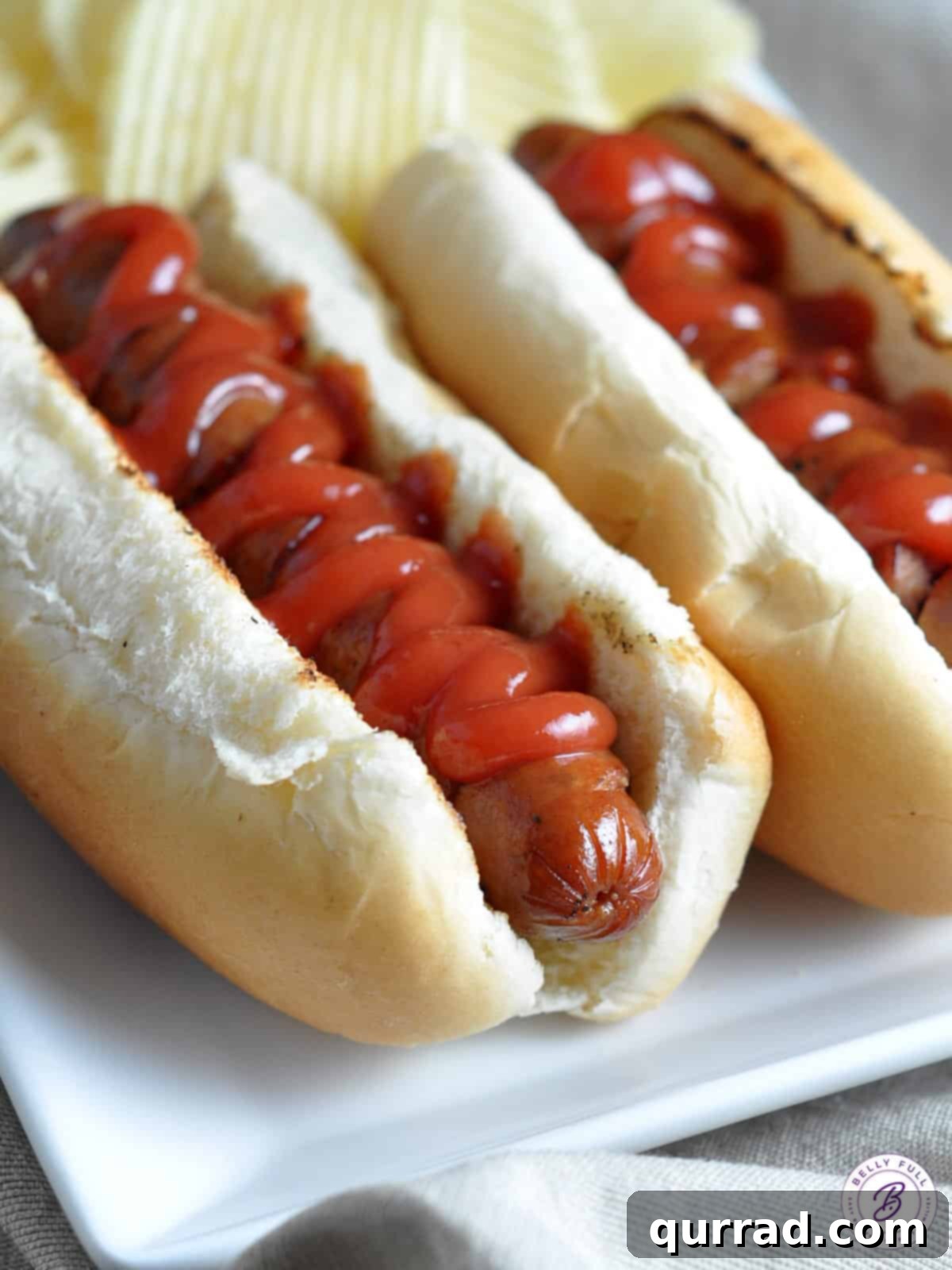 Sizzling Spiral Hot Dogs 4 Spiral grilled hot dog nestled in a bun, topped with a generous dollop of ketchup.