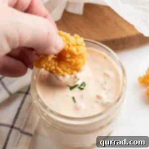 deep fried shrimp being dunked into remoulade sauce