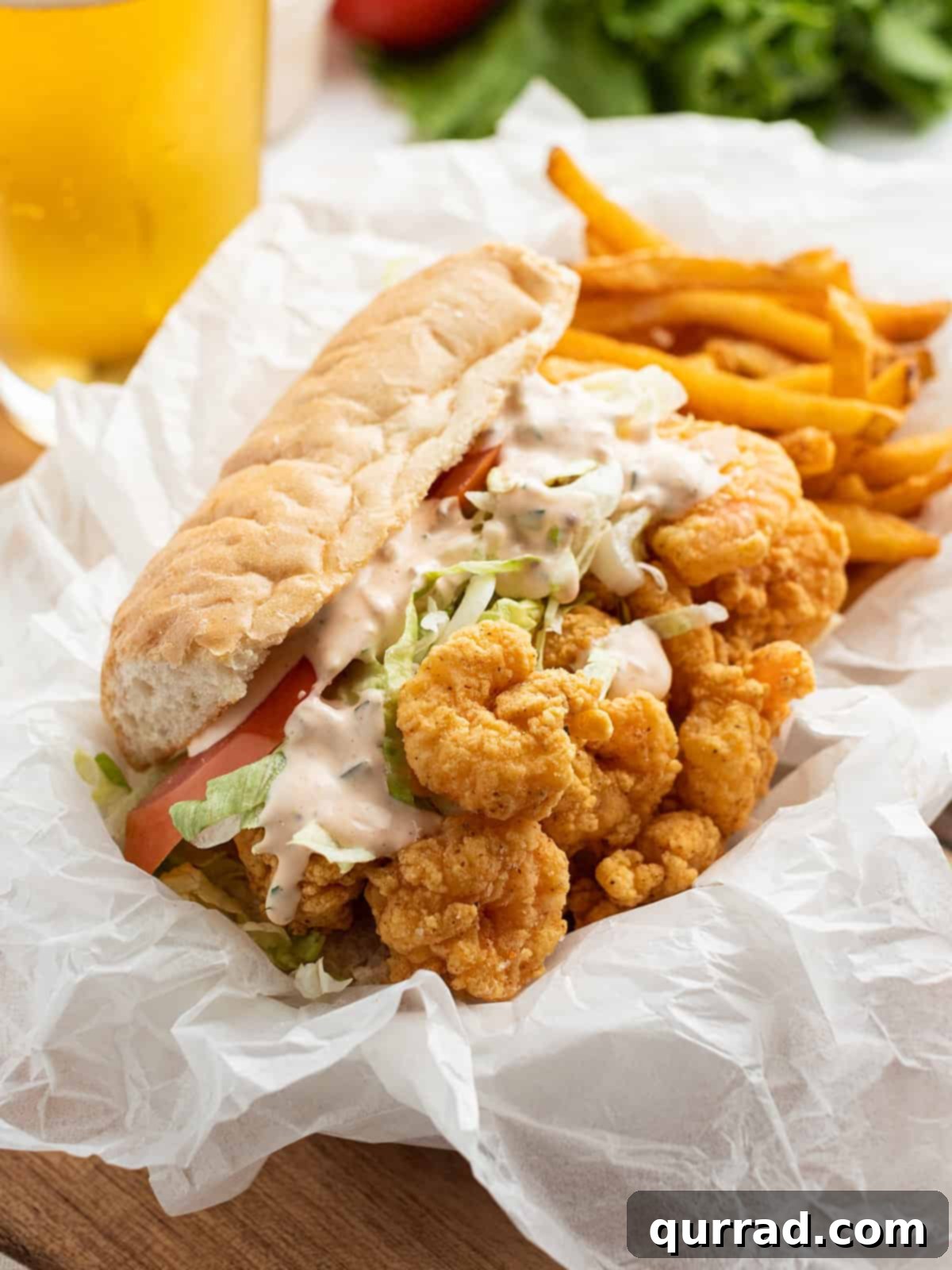 Tangy Remoulade Perfection 4 A perfectly assembled shrimp po boy sandwich overflowing with crispy fried shrimp and fresh toppings, served with remoulade sauce on the side.