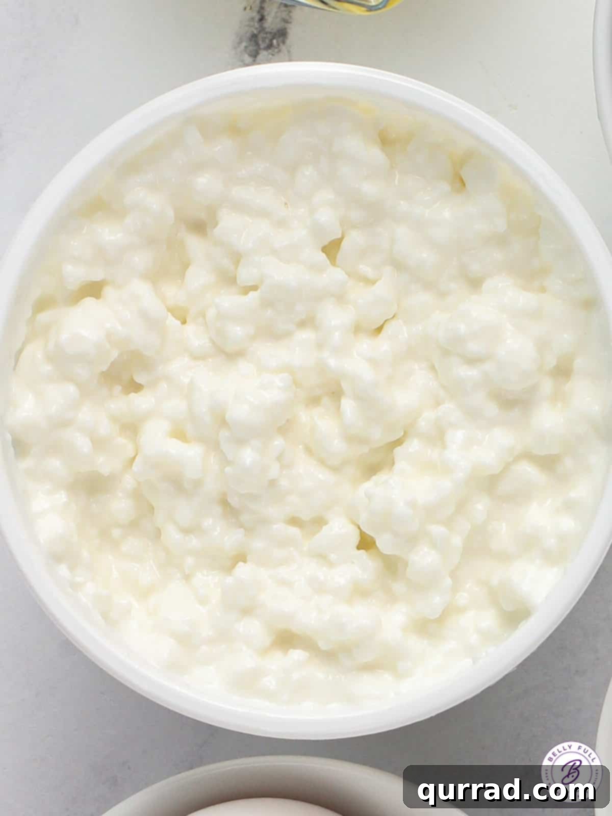 Heirloom Tomato Tartine 3 Overhead shot of a bowl of creamy cottage cheese, ready to be seasoned and spread.