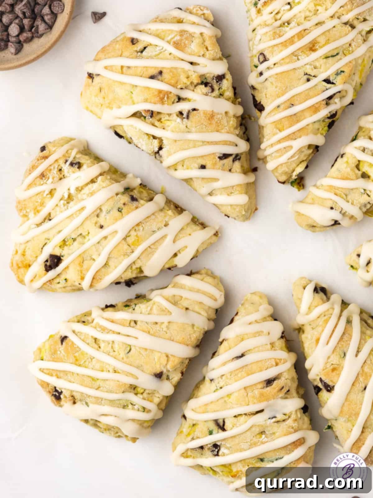 Tender Zucchini Chocolate Chip Scones 3 Overhead view of a circle of 8 triangle scones with a delicate glaze drizzled over them.