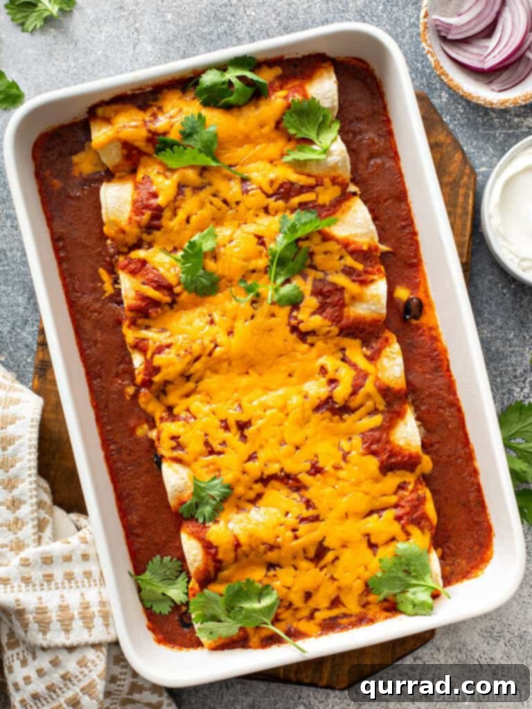 Weeknight Wonder Chicken Enchiladas 2 Chicken enchiladas covered in melted cheddar cheese in a baking dish.