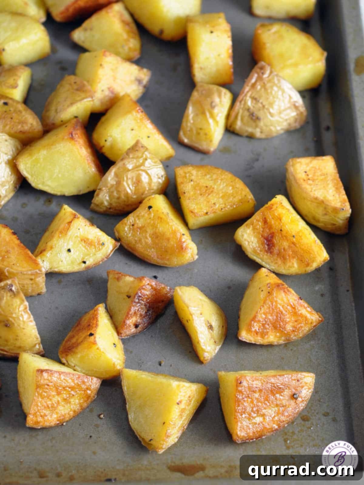 Crispy Malt Vinegar Roast Potatoes 3 golden roasted potatoes on baking sheet