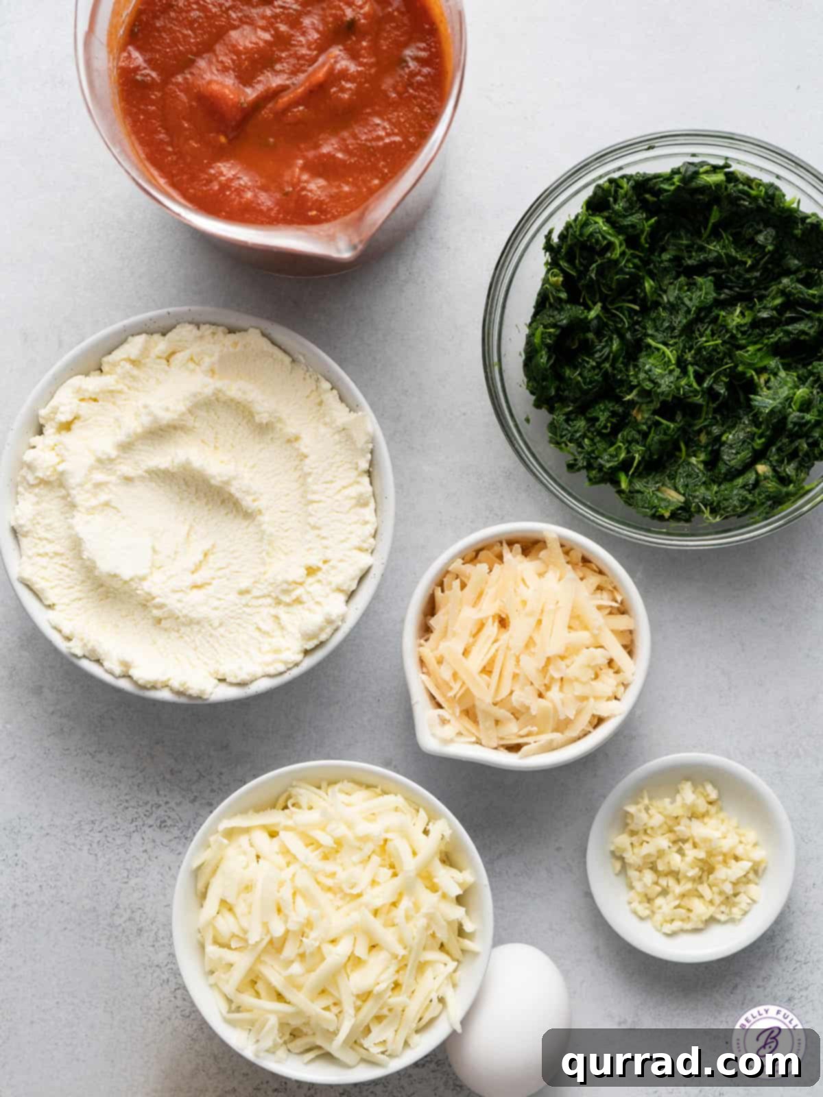 Grand Stuffed Pasta Shell Bites 3 Assortment of fresh ingredients for making stuffed pasta shells, including cheeses, spinach, garlic, and pasta.
