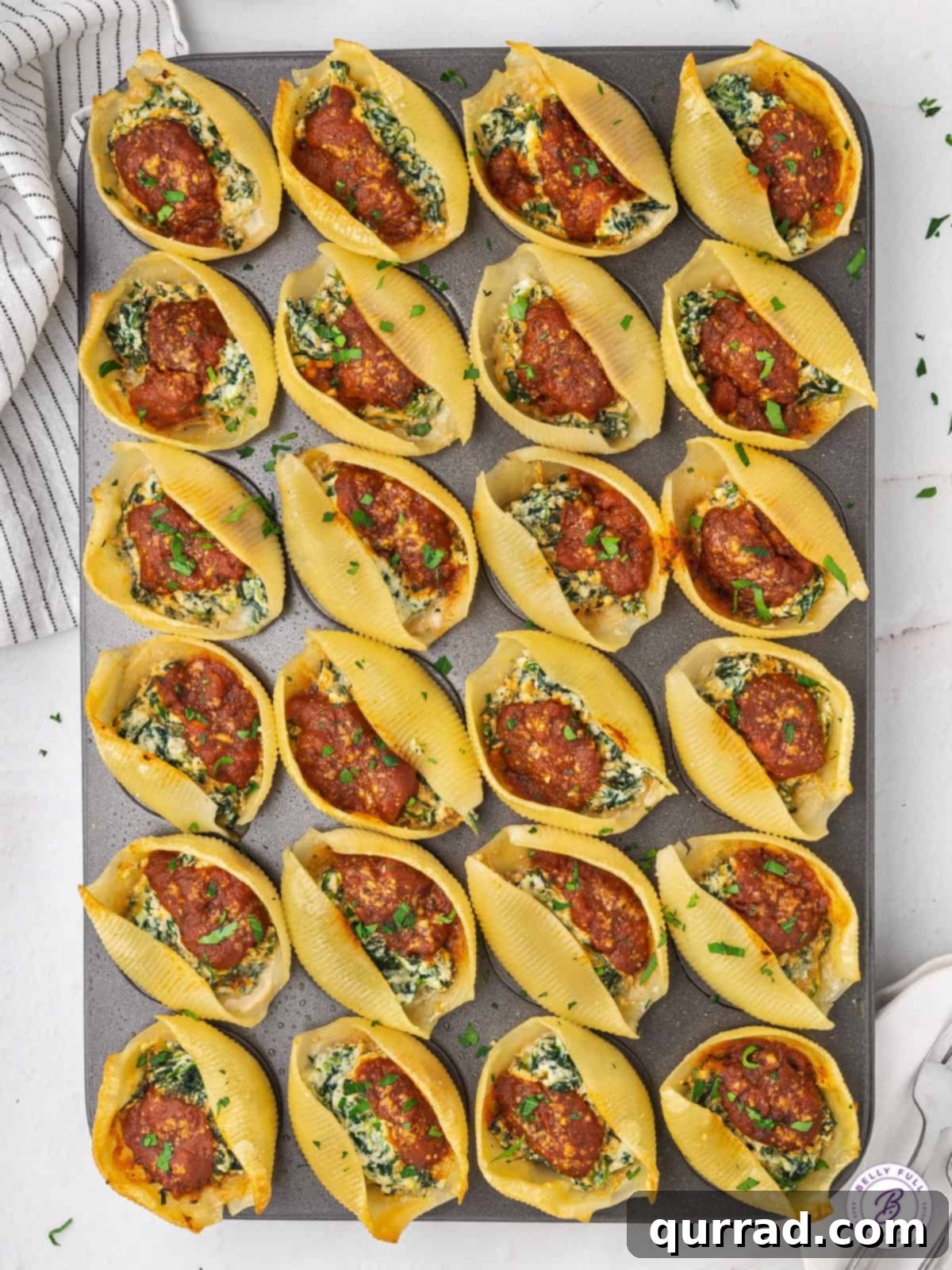 Grand Stuffed Pasta Shell Bites 4 Overhead shot of jumbo stuffed shells appetizer arranged neatly in a mini muffin tin, ready for baking.