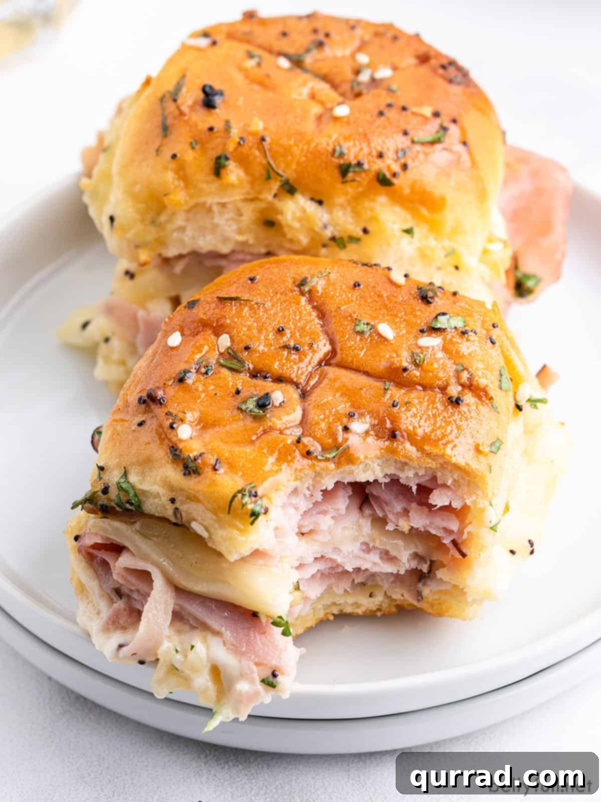 hot ham and cheese slider on plate with bite taken
