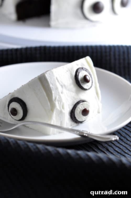 Enjoy a Slice of Spooky Fun: Easy Ghost Cake with Oreo Eyeballs A slice of the homemade Ghost Cake revealing rich chocolate cake layers and creamy frosting with a playful Oreo eyeball