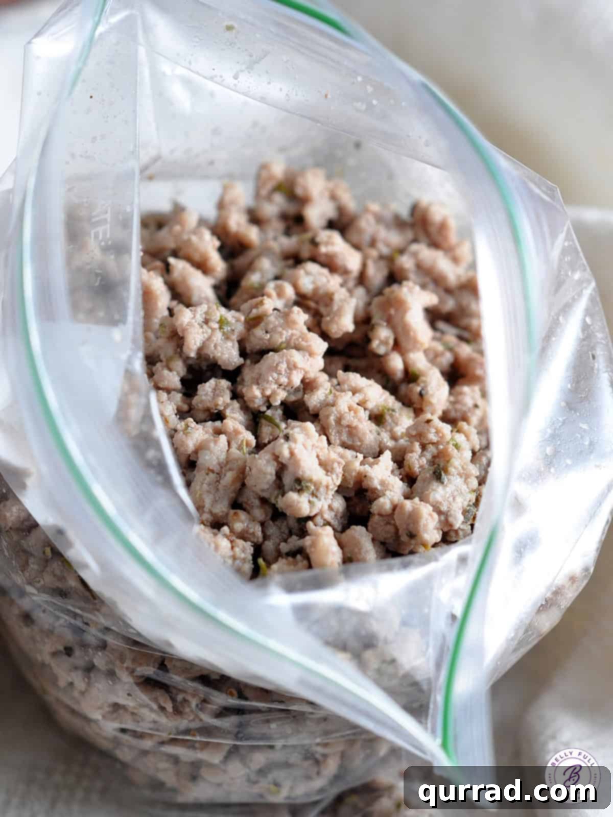 Seasoned cooked ground meat crumbles stored in a plastic freezer bag, ready for meal prep